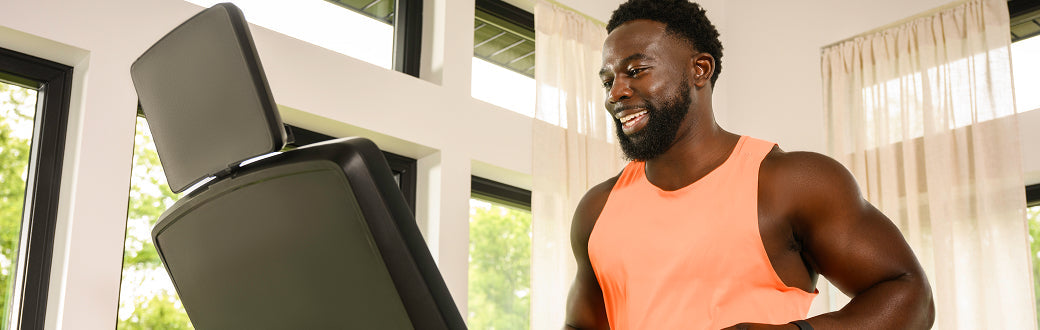 smiling man running on a bowflex treadmill
