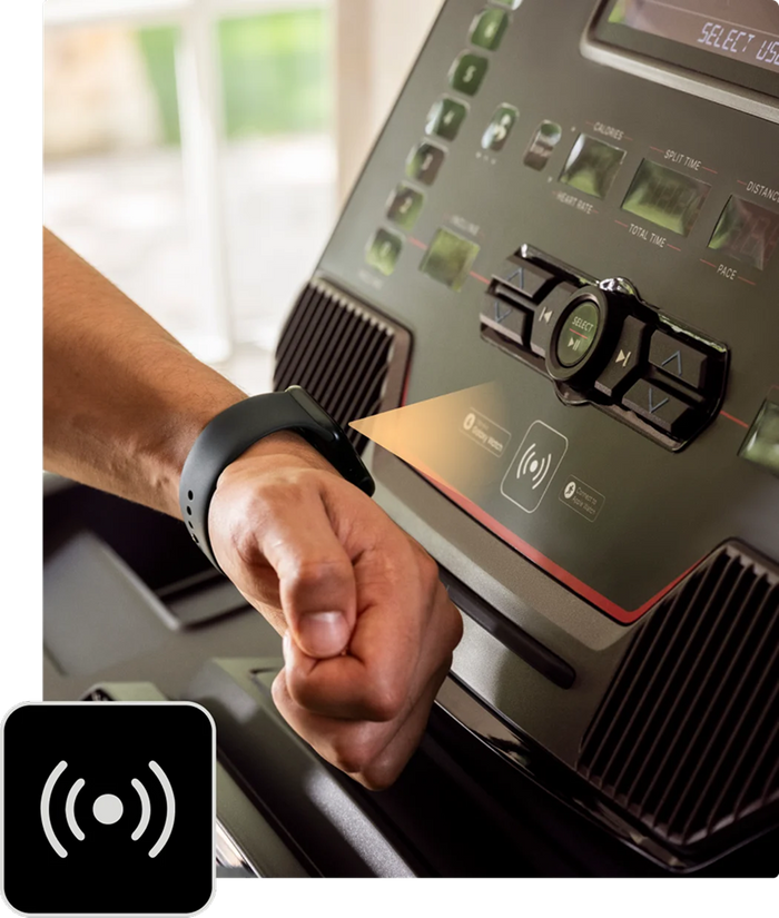 Holding a Apple Watch to the treadmill console's NFC reader