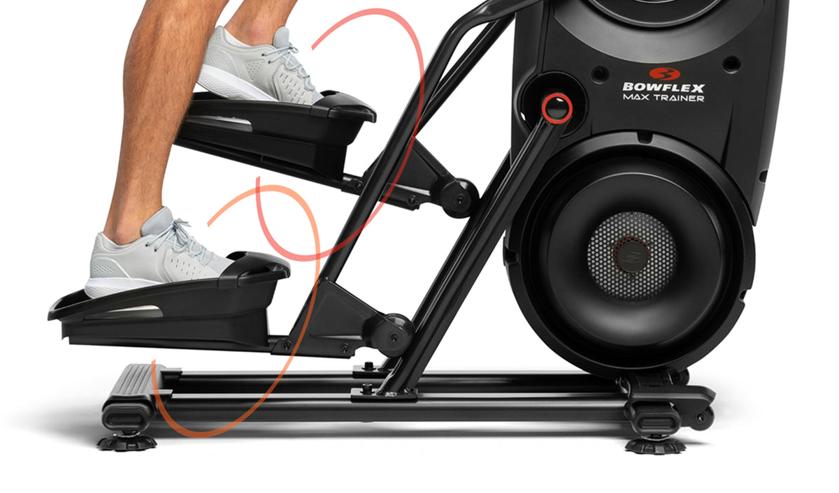 Close up side view of a person's feet on the BowFlex Max Total 16 oversized pedals.