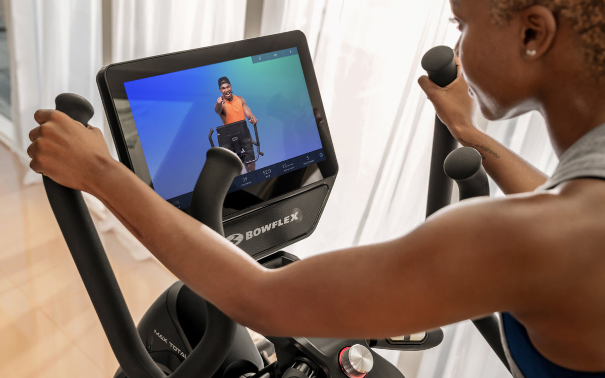 Woman using a BowFlex Max Total 16 with the JRNY fitness app