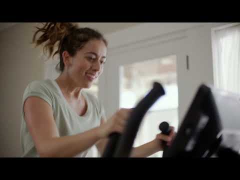 Person smiling while exercising on the BowFlex Max Total 16 in a home setting.