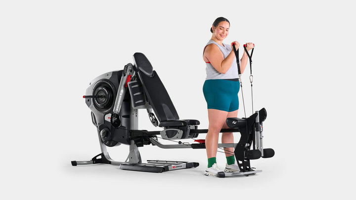 Woman doing biceps curl exercise with BowFlex Revolution
