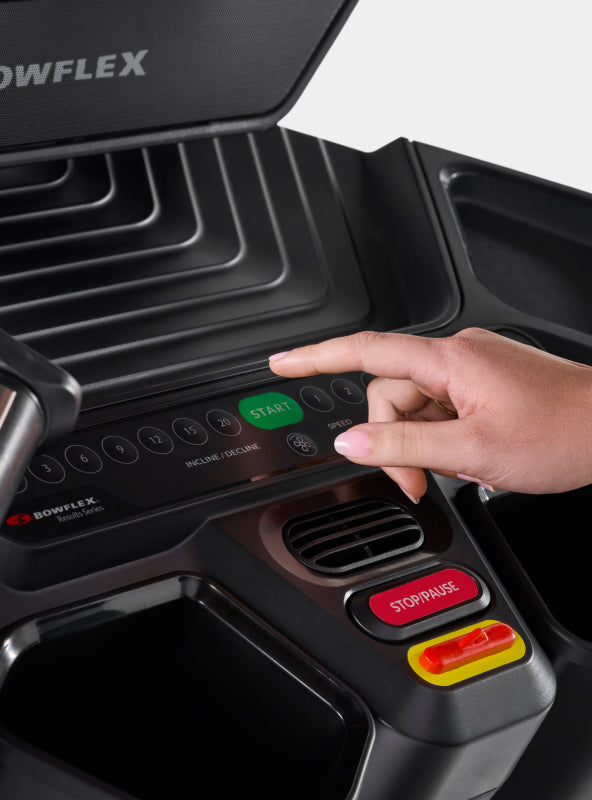 Hand hovering over the BowFlex Treadmill 22 pace adjustment buttons.